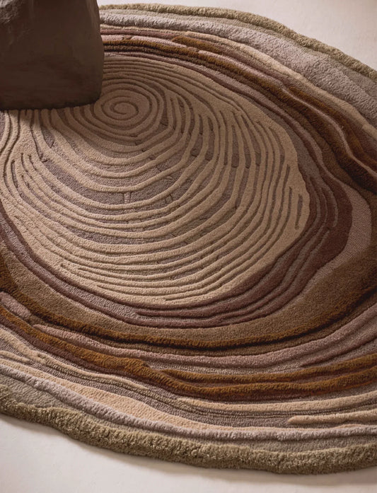 Beige wool rug with brown concentric contour lines and raised textured detailing