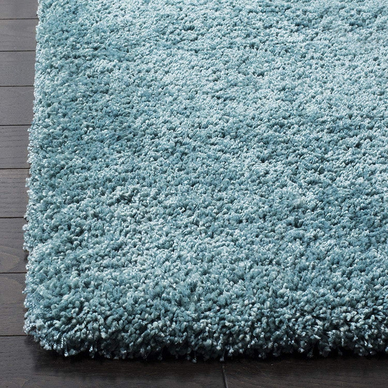 Aqua blue carpet showing thick shaggy pile and textured edge detail