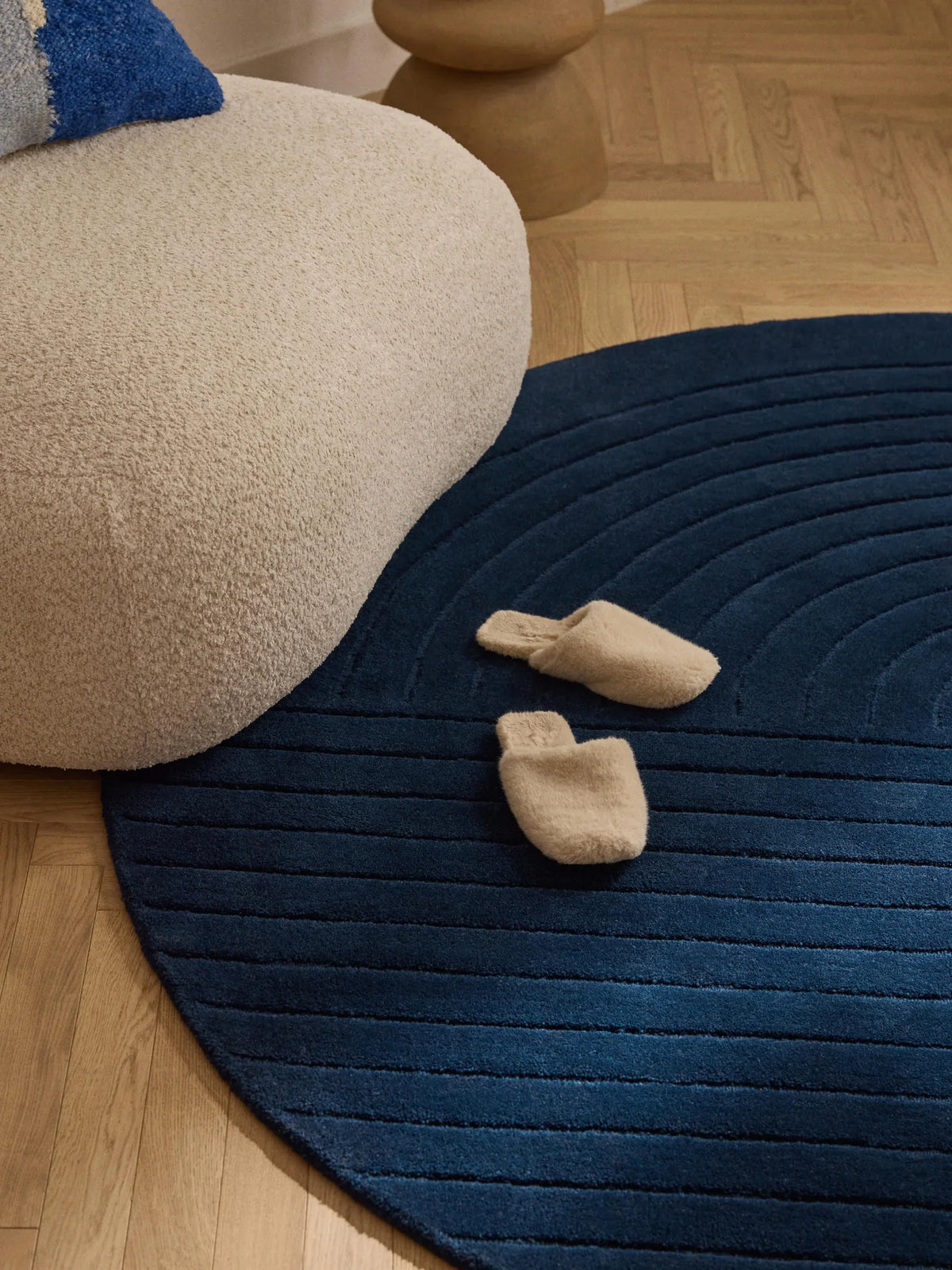 Navy circle rug with modern round design styled beside neutral furniture in a living room