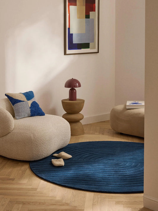 Navy circle rug with round design and subtle concentric texture styled in a modern living room