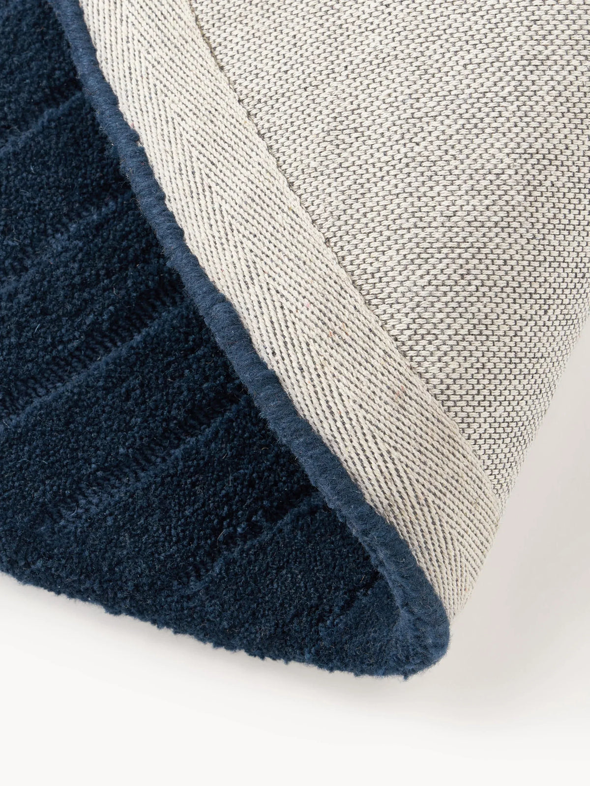 Navy circle rug showing round edge and carpet backing detail