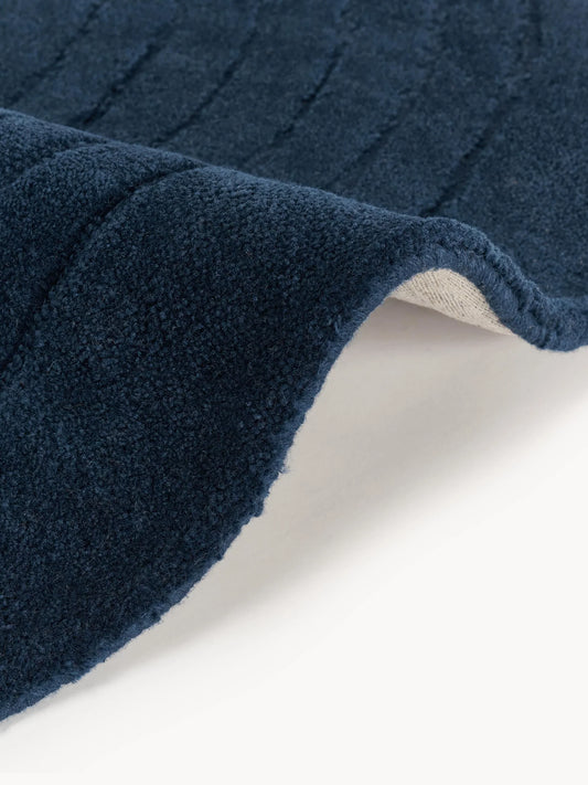 Navy circle rug close-up showing soft textured surface and subtle linear detailing