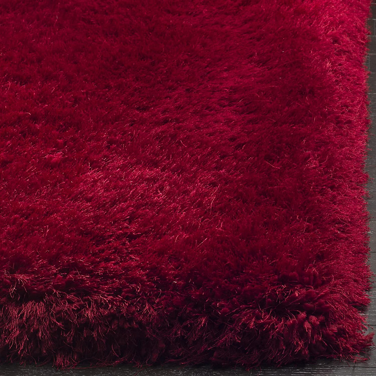 Red carpet close-up showing dense deep red shaggy polyester texture