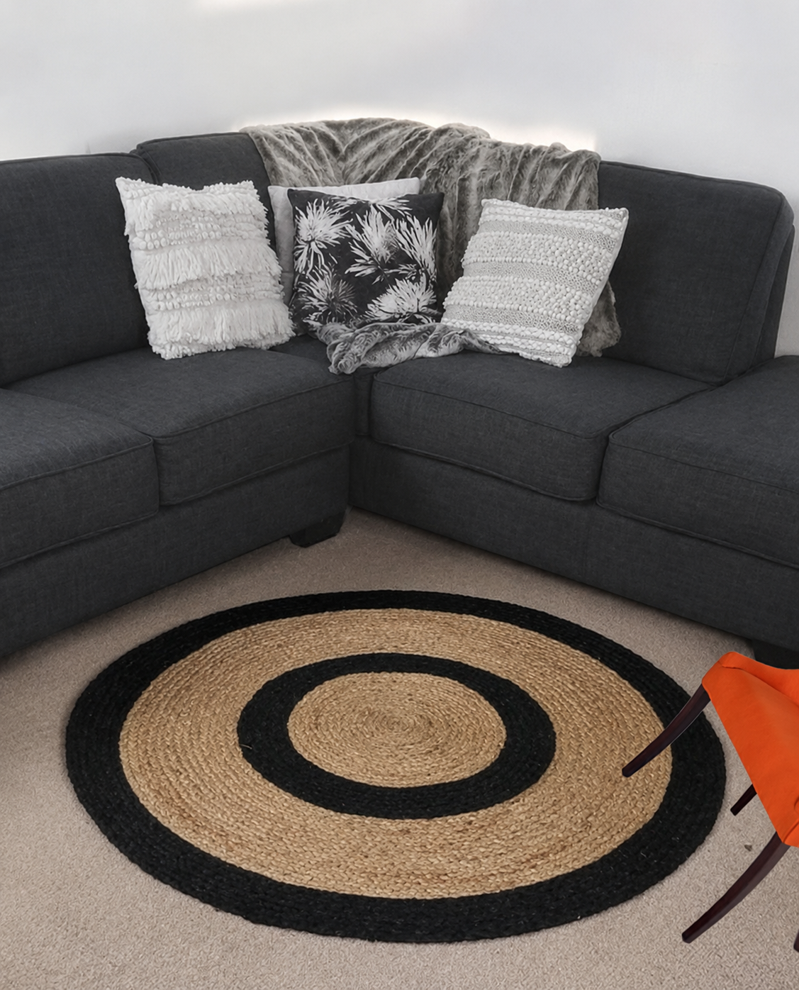 Round jute rug in natural beige with black concentric borders styled in a modern living room